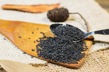 black sesame seeds on wood background
