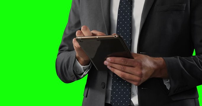 man using a digital tablet on green background