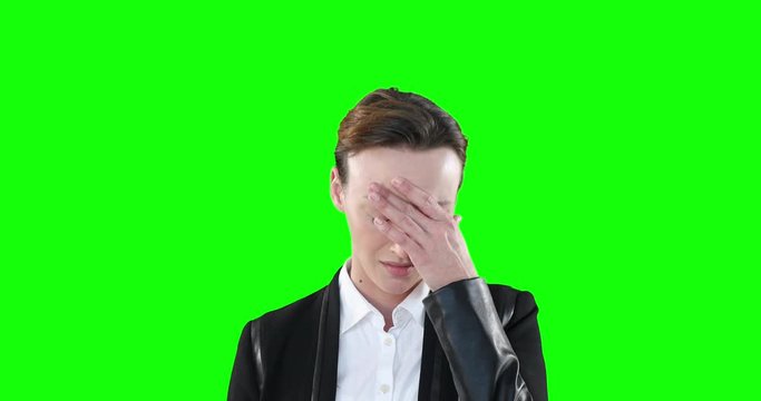 Sad woman looking at camera on green background