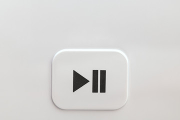 Close-up of the start and pause button on a gray background. Start-up