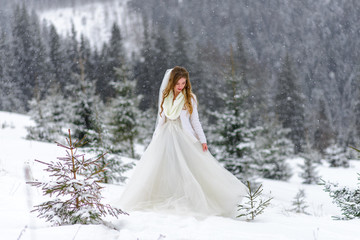 Fototapeta na wymiar Beautiful bride on a background of mountains covered with snow.