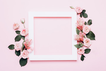 Square white frame and pink roses on pink background. Beautiful flower arrangement for your design