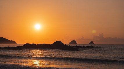 Naklejka na ściany i meble Golden hour sunrise on the pacific coast