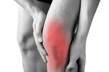 Black and white picture .Knee pain .man stand hand caught at the knee.  health concepts