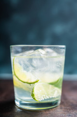 Rum based cocktail caipirinha (variation of cuba libre) on the rustic background. Selective focus. Shallow depth of field.