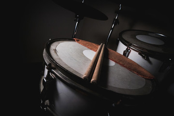 Detail view of old white drum set from the 70s with its drumsticks