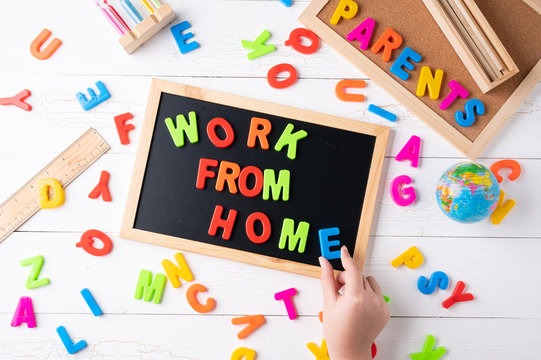 `Work From Home` Words On A Modern Board On A White Wooden Surface, Top View. Overhead, From Above, Flat Lay.