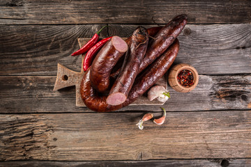 Smoked sausage on a wooden rustic table, natural product from organic farm, produced by traditional methods. menu banner space for text