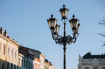 An old vintage lantern in the historical center of Lviv on blue sky background. The concept of spring city.