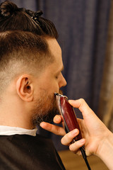 Bearded man with unshaven beard, brutal hipster guy with moustache, getting stylish beard shaving...