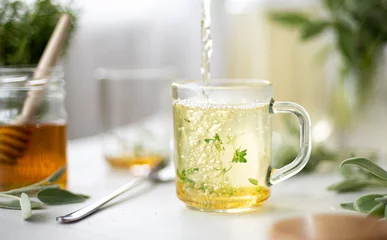 Deurstickers hot herbal tea with mint in a glass bowl © Ольга Гагарова