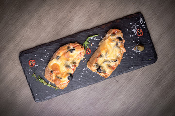 Two brutal sketches with cheese, olives, mushrooms on stone plates. restaurant giving. for the menu of cafe. wooden