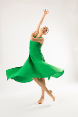 Adult woman dancing in the studio in a green dress.