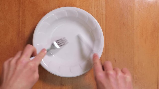 Fork and knife scratching plate makind a disturbing screeching sound