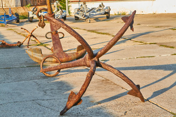 Old rusty four-legged anchor in the seaport Anapa
