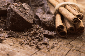 Cinnamon sticks and dark chocolate on a wooden background