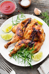 Butterflied grilled whole chicken served with limes and rosemary.