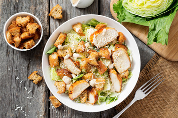 Classic caesar salad with grilled chicken fillet and parmesan cheese. top view - obrazy, fototapety, plakaty