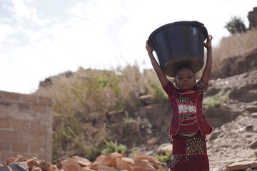 Body Shot of African Black Girl Transporting water Bucket