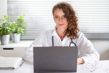 portrait of female doctor working on laptop telemedicine concept