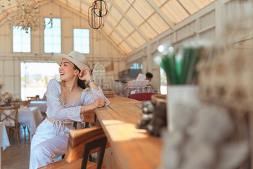 Portrait of stylish young woman in dress vintage style and hat sit posing in the coffee shop decoration in vintage style