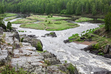 Beautiful landscape with big stones in water riffle of mountain river. Powerful water stream among boulders in mountain creek with rapids. Fast flow among rocks in highland brook. Small river close-up