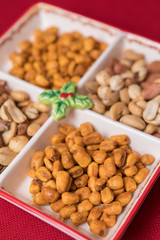 mixed nuts plate on red background. Seed, sauce corn and mixed nuts