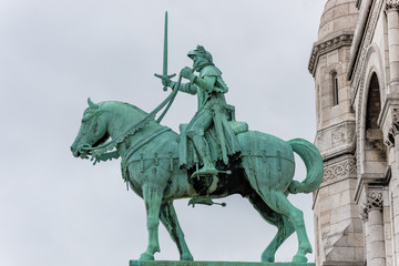 Fototapeta premium Equestrian statue of of Saint Joan of Arc at the Basilica of the Sacred Heart of Paris, at the summit of the butte Montmartre, the highest point in Paris, France