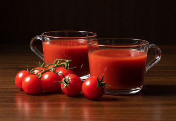 Tomato juice and tomatoes set against a wooden backdrop