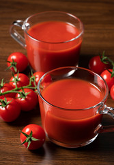 Tomato juice and tomatoes set against a wooden backdrop