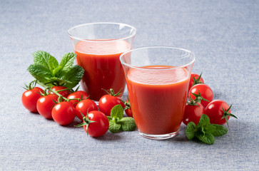 Tomato juice and tomatoes on a blue background