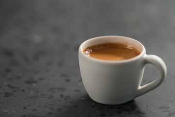 hot espresso in white cup on concrete background with copy space