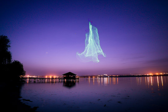 Fishing pier with lake house at night with drone imitating northern Aurora Borealis lights - Powered by Adobe