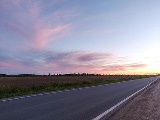 Fototapeta premium pink sunset over the field and road