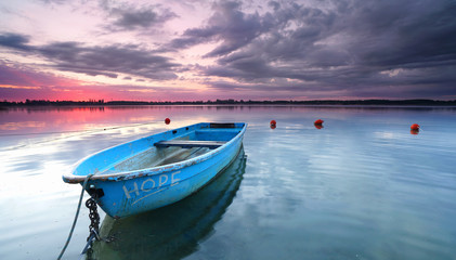 Sonnenuntergang am See mit Holzboot