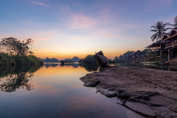 Beautiful landscape view of sunrise and old wooden boat drop nearly the river in front of guest house from Don Det the famous place for tourist to relaxing at Siphondon island, Laos.