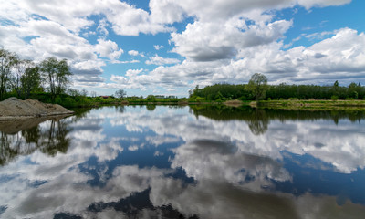 calm scene of beautiful sky with cumulus clouds reflection on the lake