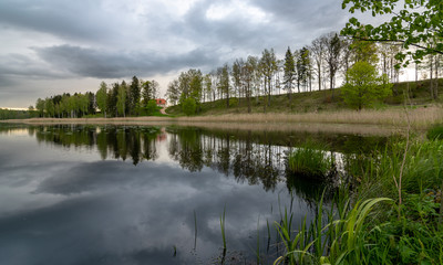 Fototapeta na wymiar spring landscape with beautiful sky, clouds and tree reflections in the water