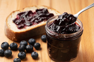 Blueberry jam set against a wooden backdrop