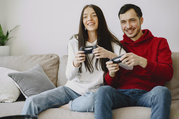 Couple with joysticks. People at home. Pair playing a video games.