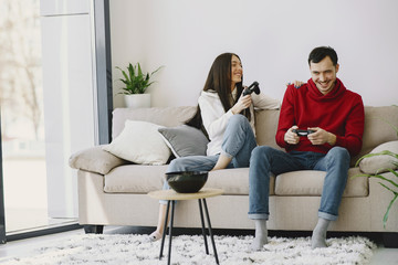 Obraz premium Couple with joysticks. People at home. Pair playing a video games.
