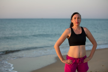 Fototapeta na wymiar Middle-aged woman in sportswear on a background of the sea.
