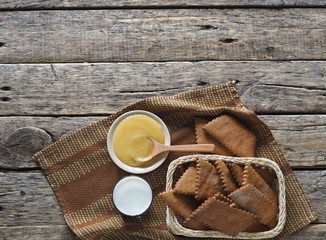 The view from the top.Background about healthy natural dessert. Diet cookies made from rye flour, a glass of milk and honey on an ancient wooden table.