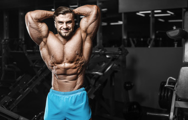 Obraz na płótnie Canvas Bodybuilder strong man pumping up abs muscles