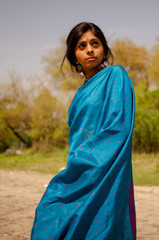 Girl in blue saree standing with a smile on her face