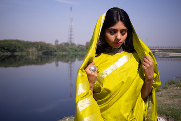 Indian girl wearing green saree standing in a landscape