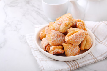 Freshly baked cottage cheese and sugar cookies (triangles, angles) in a marble background. Crow's feet.