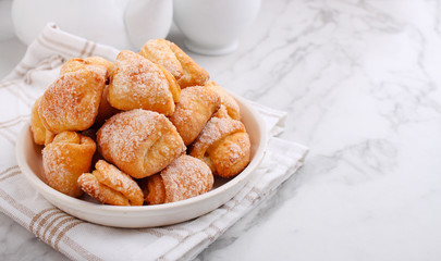 Freshly baked cottage cheese and sugar cookies (triangles, angles) in a marble background. Crow's feet.