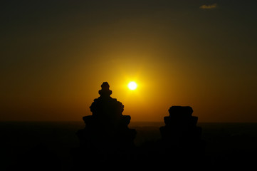 sunset at Phanom Bakheng , yellow and orange sky and foreground with silhouette  two towers Seim Reap CAMBODIA IN 
