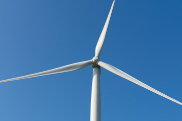 Close-up of the propellers of a wind turbine with a clear blue sky in the background